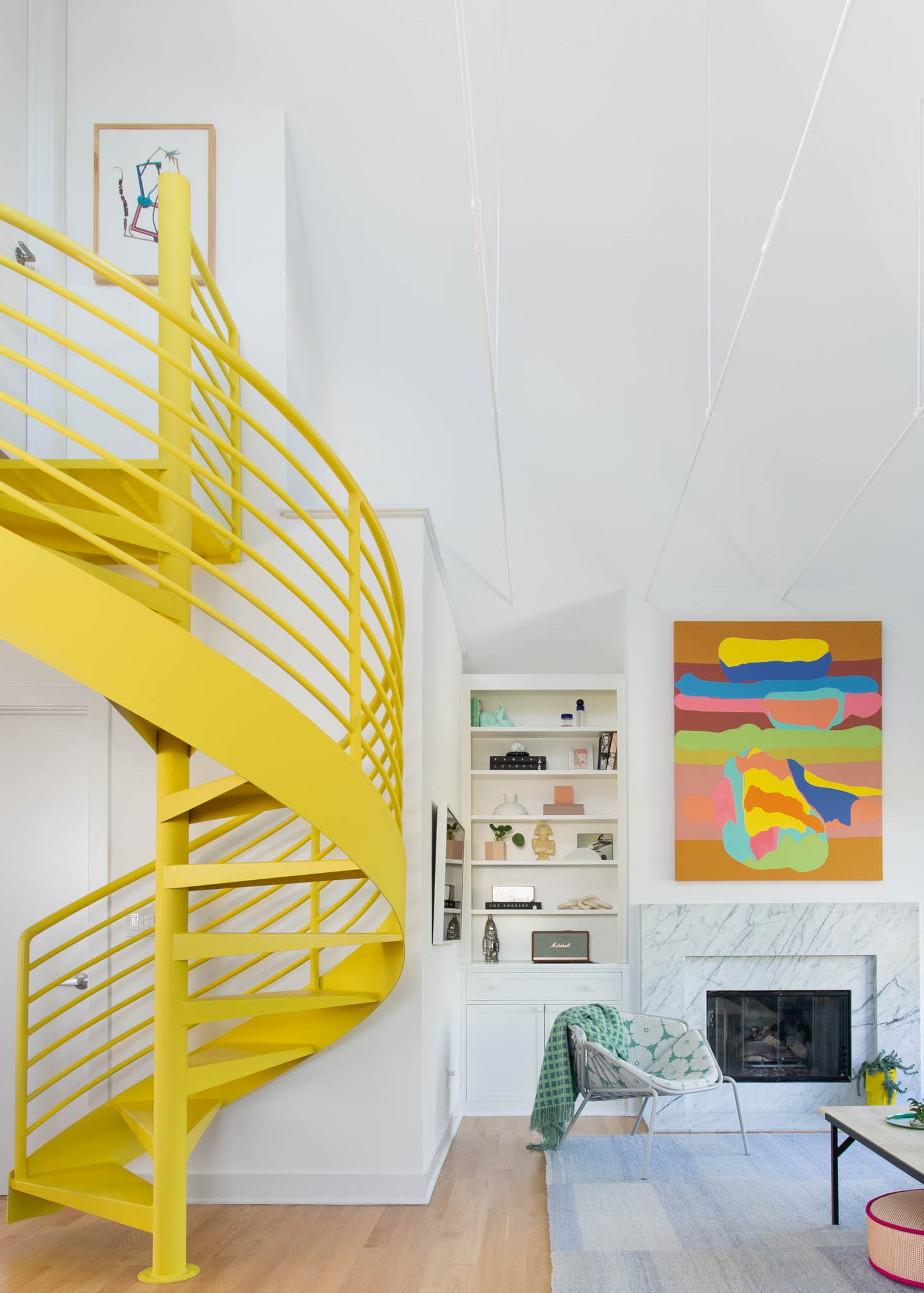 living room with a yellow staircase and vibrant artwork