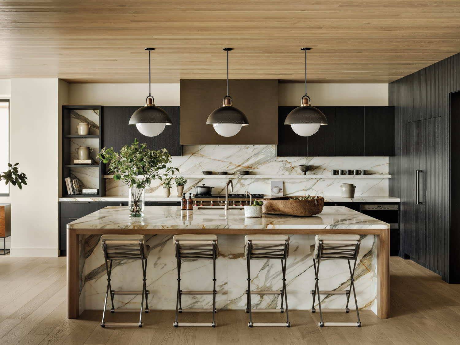kitchen with wood ceilings, black cabinetry and a brass hood with white marble backsplash and island