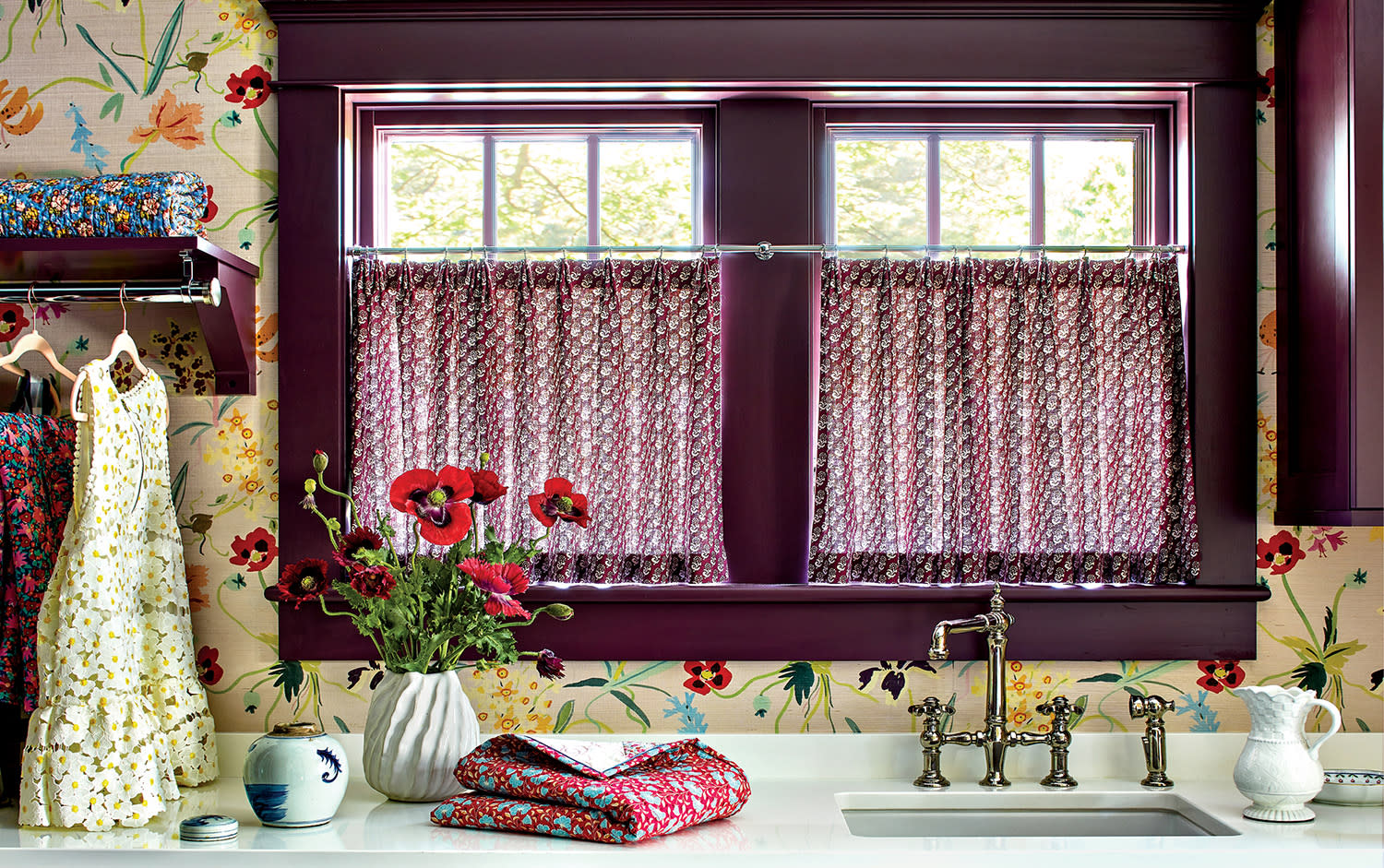 laundry room with floral wallpaper and red-accented window trim