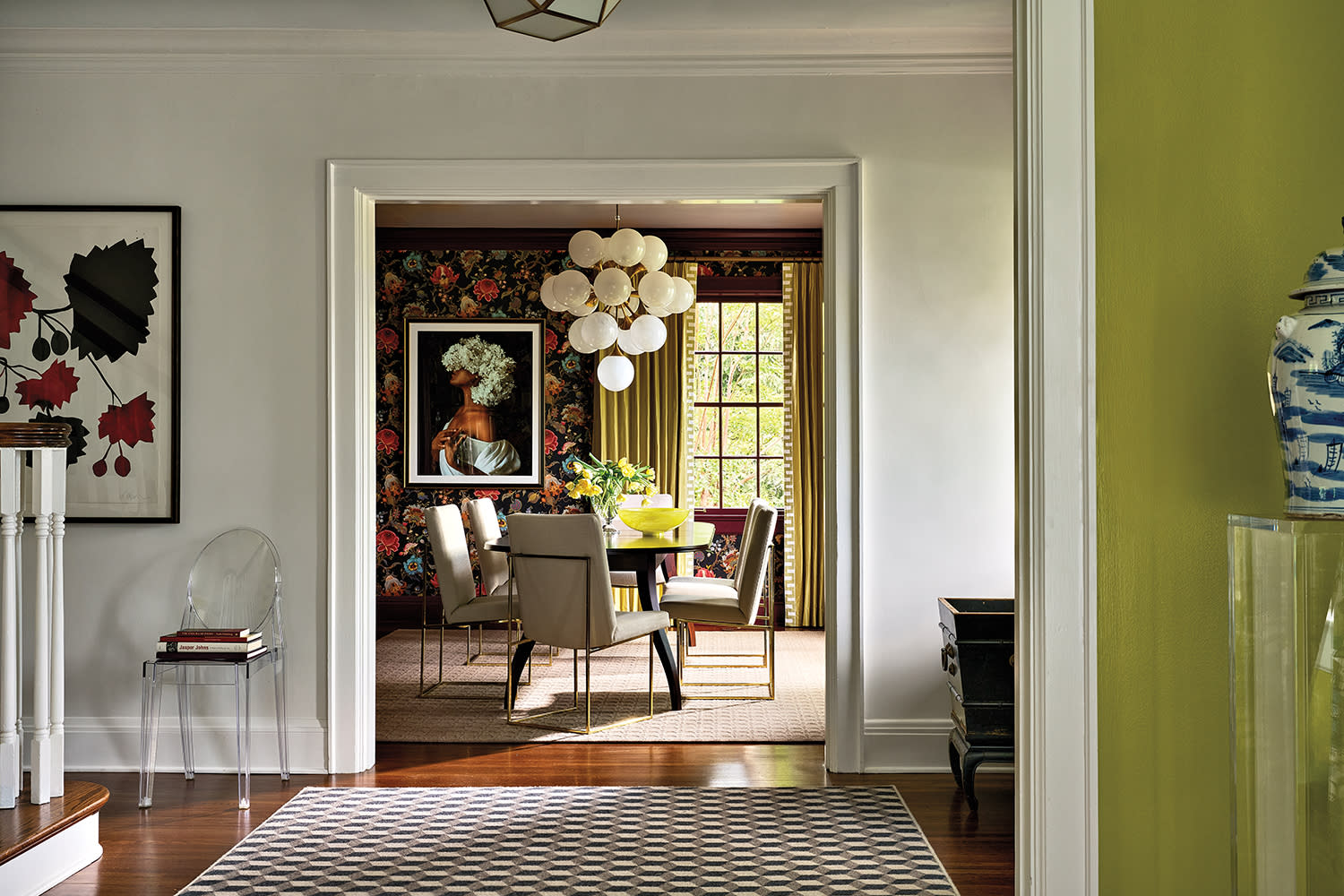 dining room viewed through a door with its walls covered in floral wallpaper and a bubble chandelier