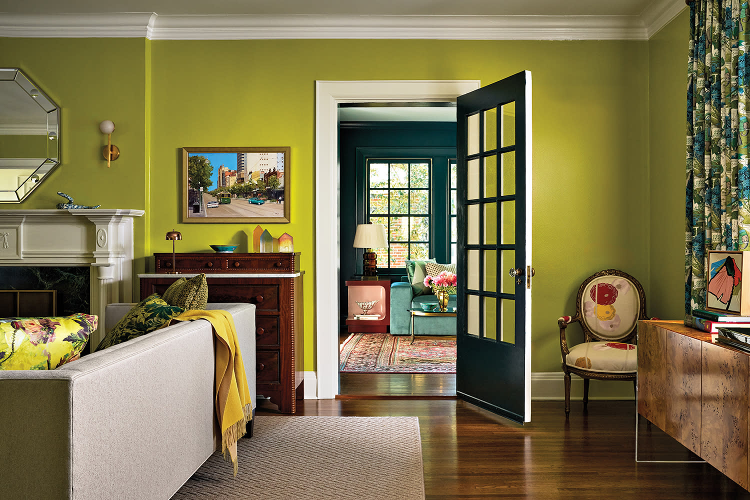 eclectic green living room with a door opening to a dark blue sitting room